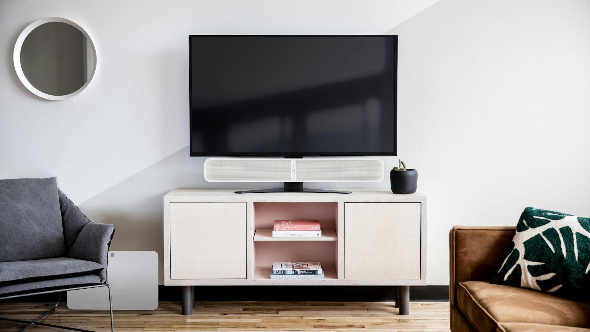 Soundbar van Bluesound bevestigd aan voet tv.