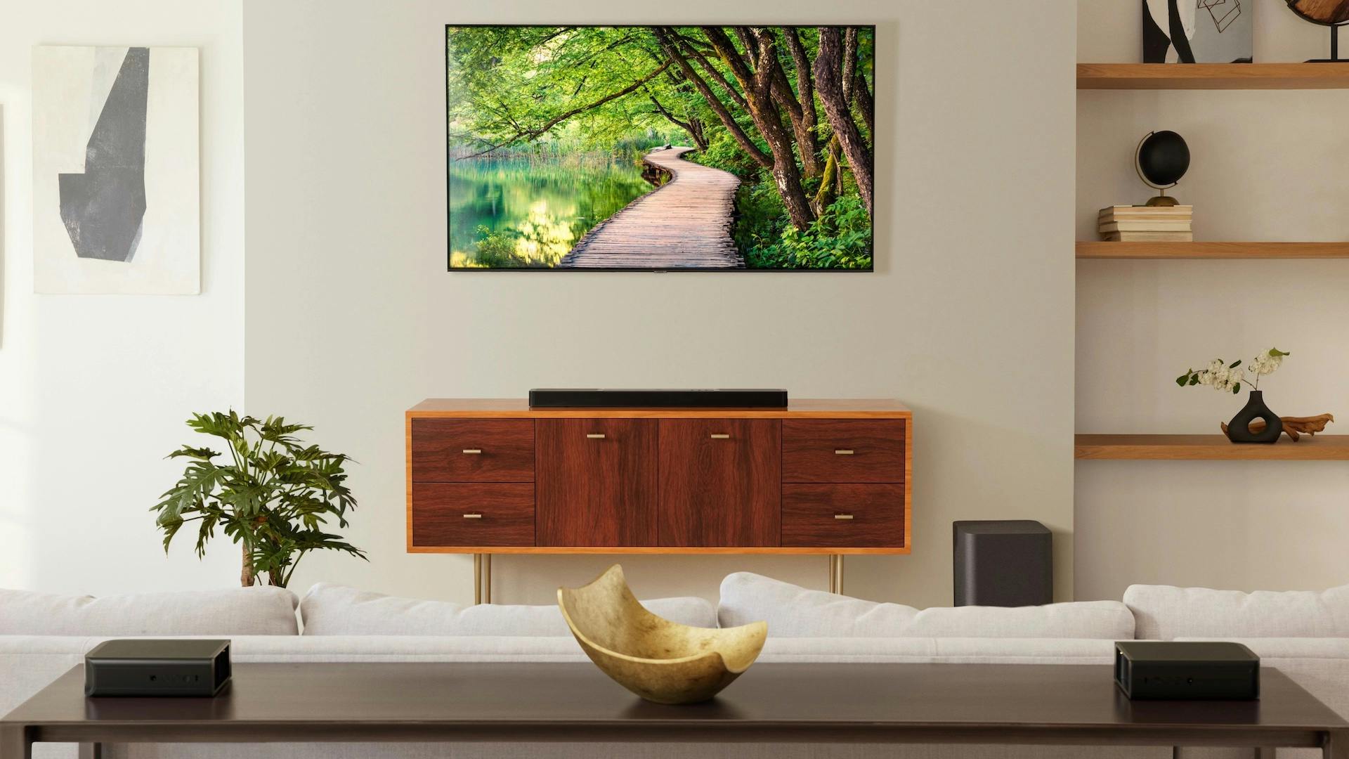 Een compacte soundbar op een meubel onder een tv.