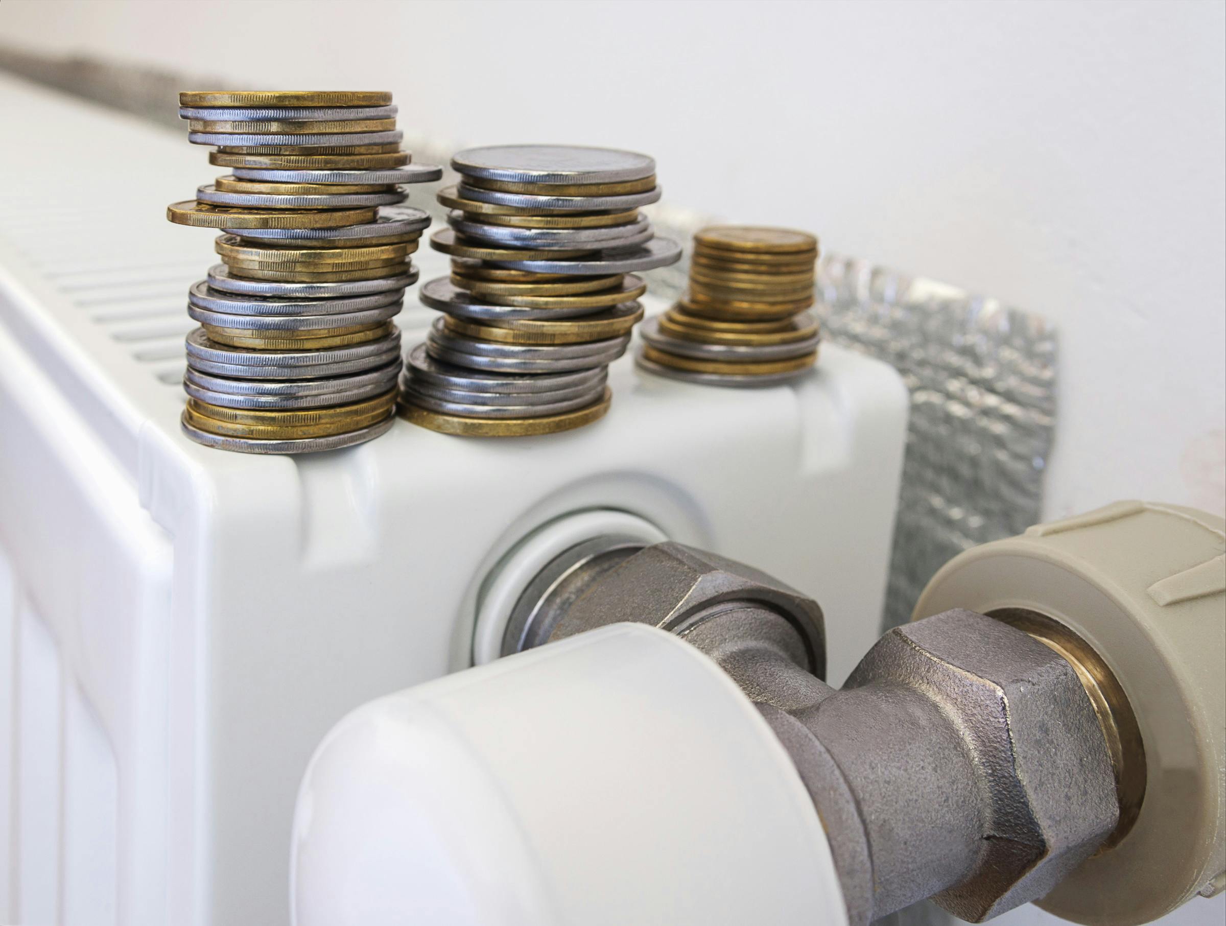 Radiator met radiatorfolie erachter en munten bovenop