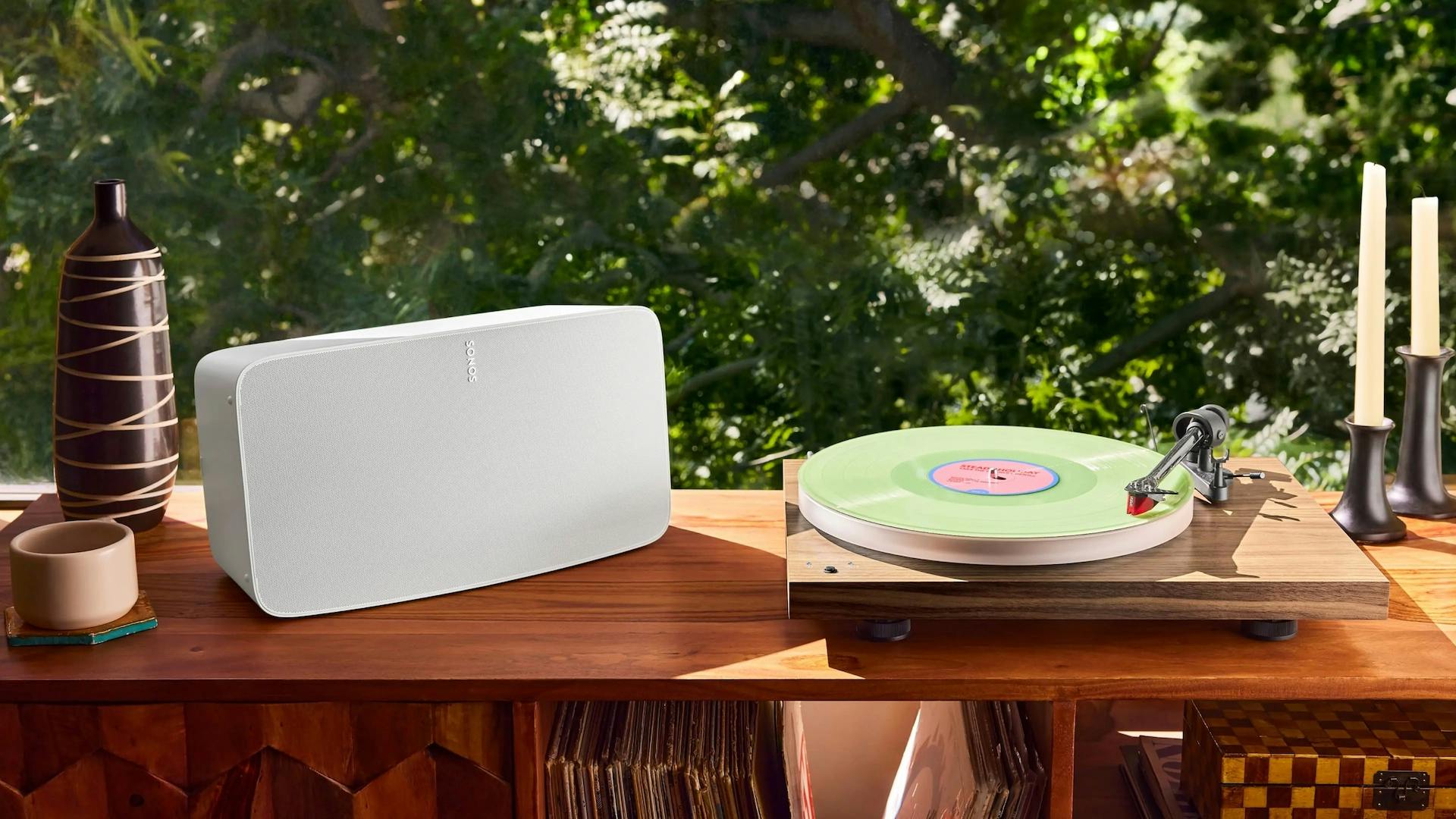 Een witte Sonos Five met platenspeler op een kast.