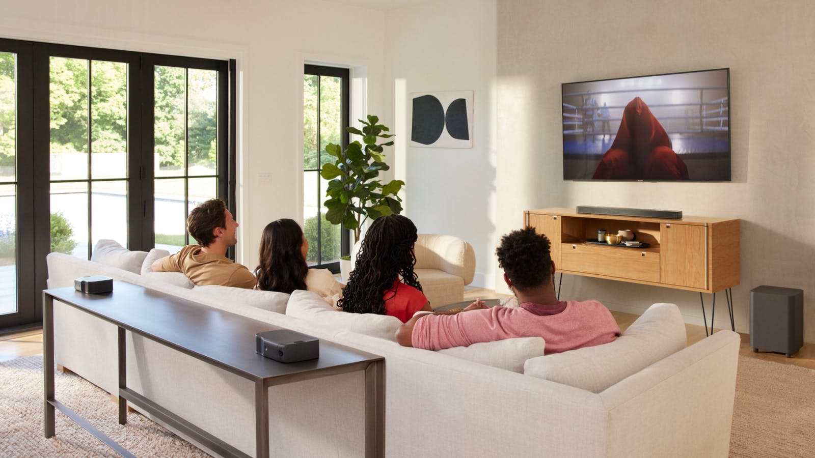 Een JBL-soundbar met afneembare speakers en subwoofer in een woonkamer.