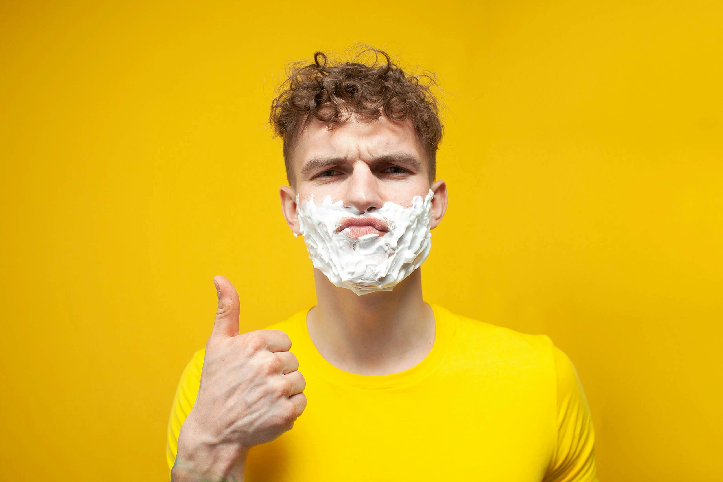 Man met scheerschuim op zijn kin