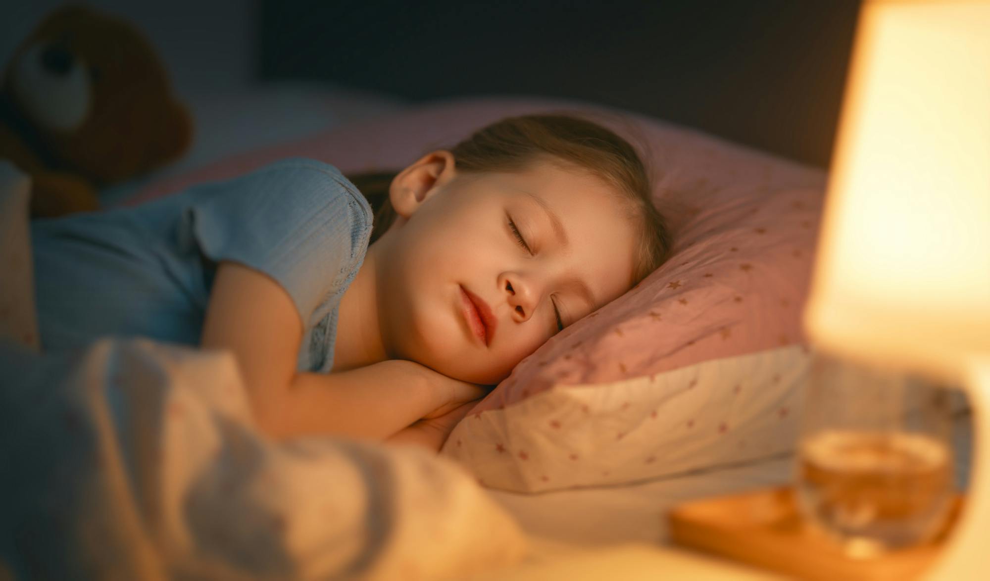 Meisje slaapt met nachtlamp ernaast