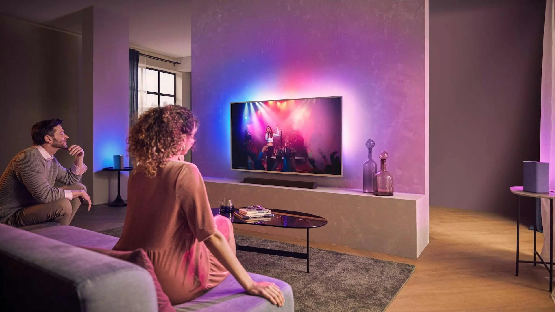 Woonkamer met Philips-tv en Ambilight en een Play-Fi-speaker.