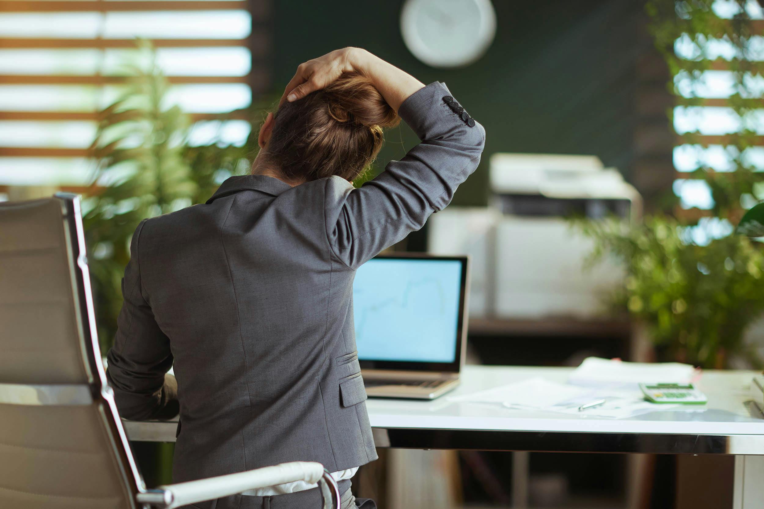 Vrouw op kantoor die haar nek stretcht