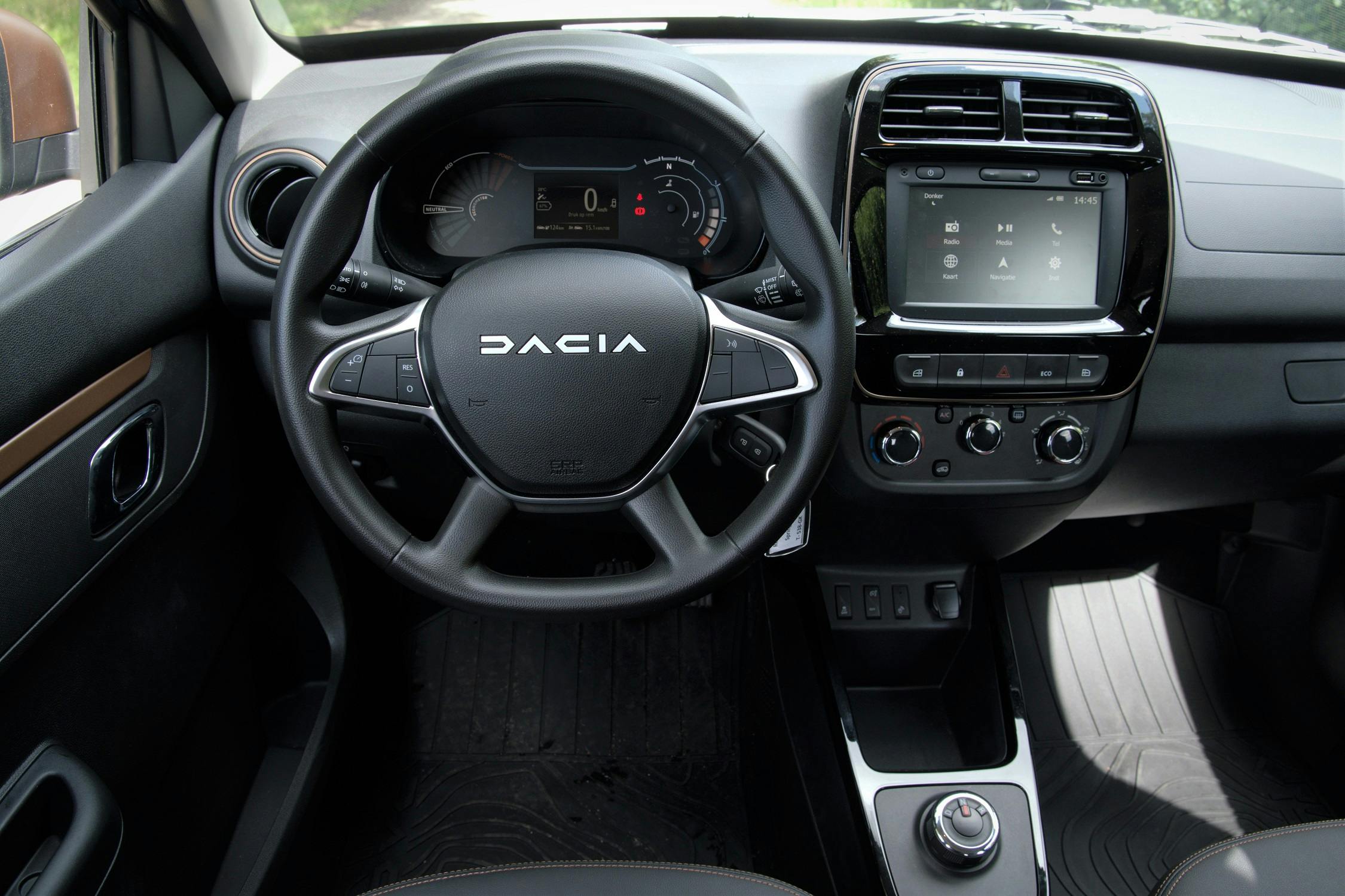 Het interieur van de Dacia Spring is opgebouwd uit robuuste materialen. De koperkleurige details zijn voorbehouden aan de Extreme-versie.