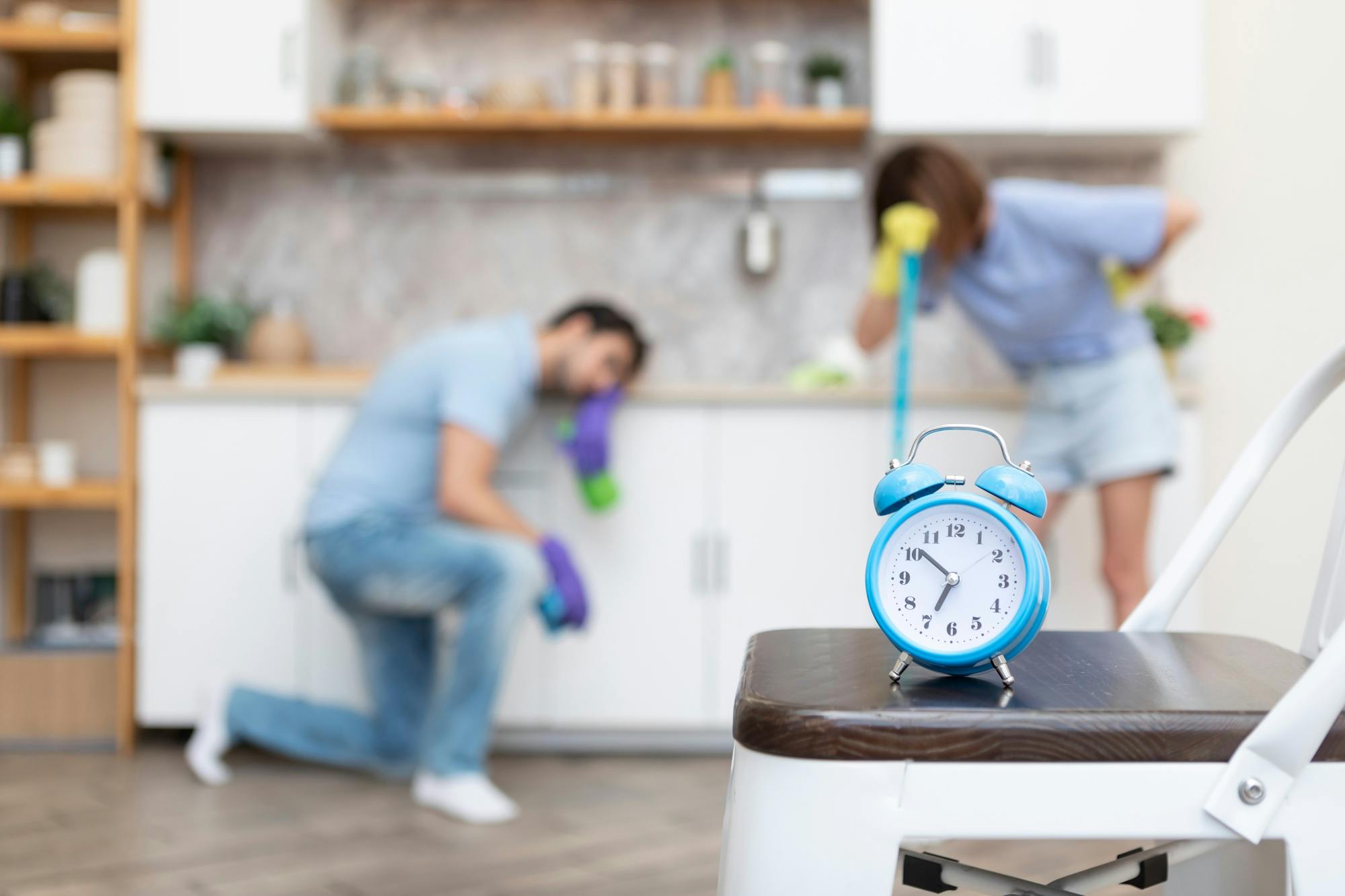 Man en vrouw maken schoon met een wekker erbij