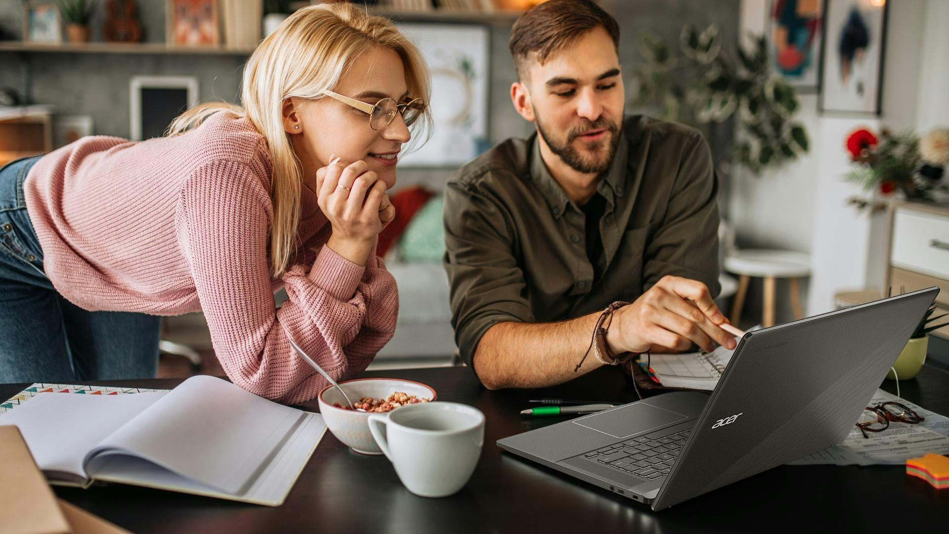 twee mensen die samen achter de laptop zitten