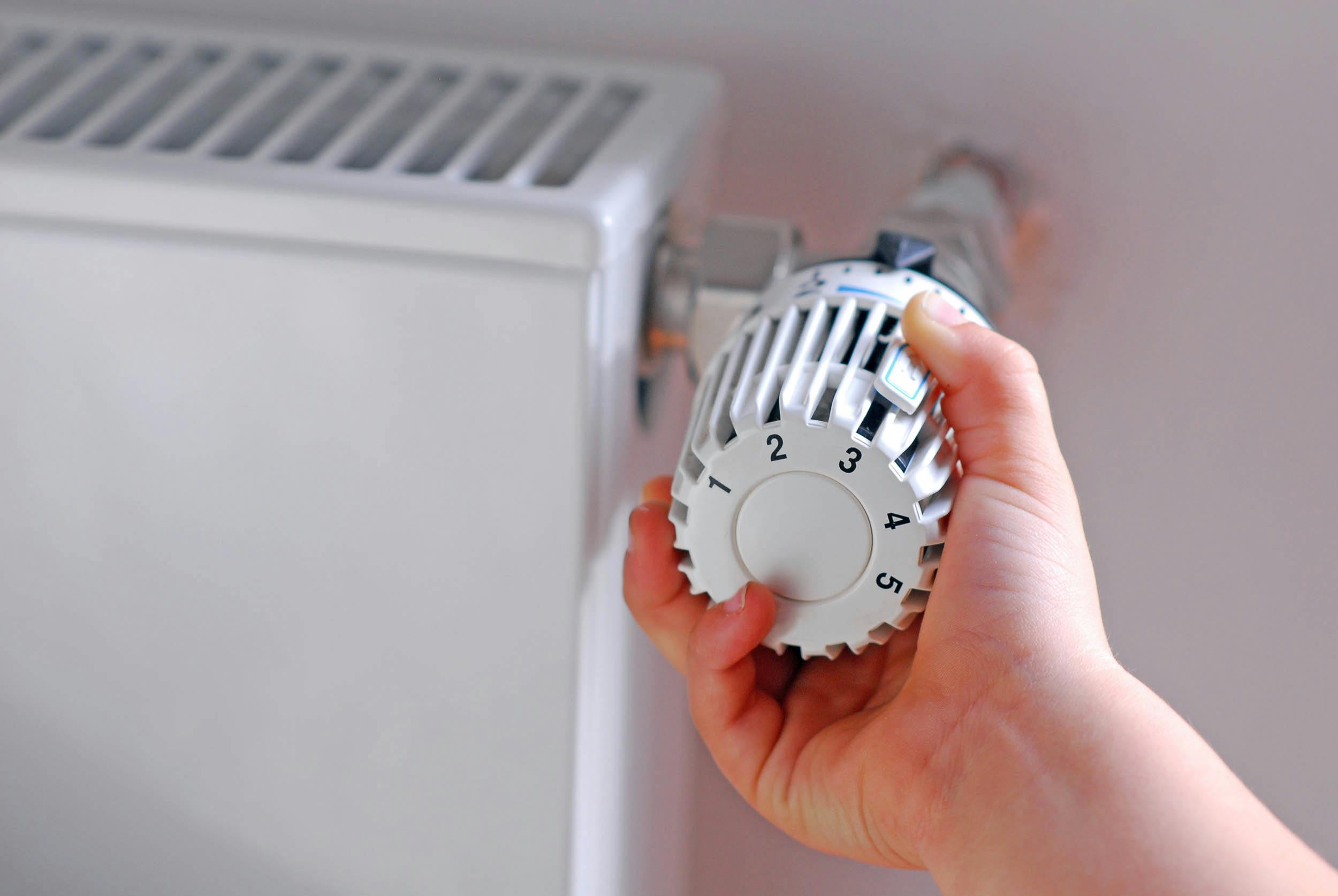 Kind dat aan de thermostaat draait