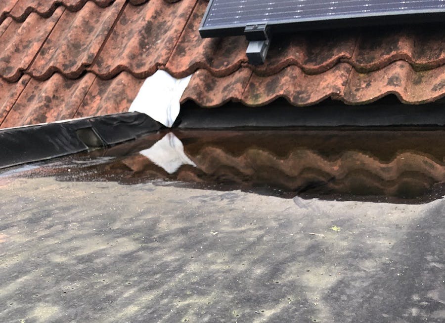Achterstallig dak met plas water