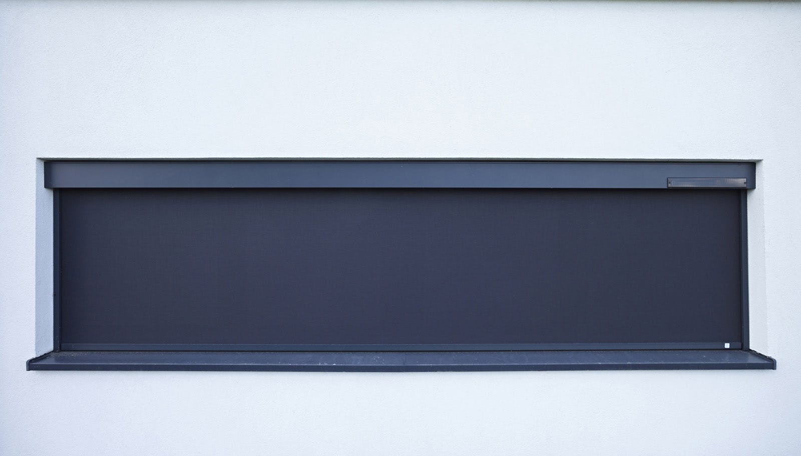 Aan de zijkant van de rolluikkast zit een zonnecel.