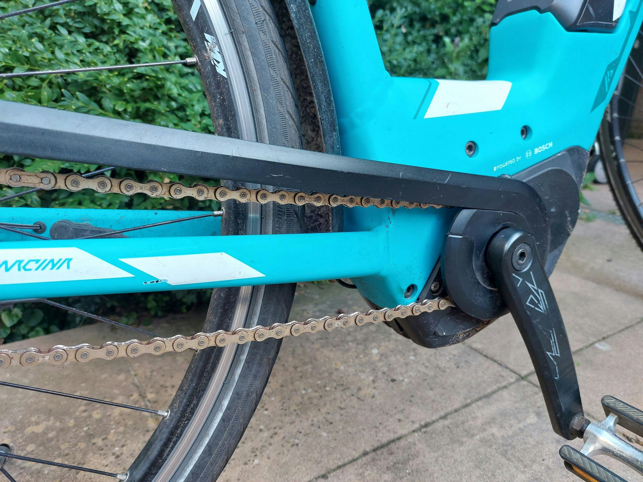 Bij een half-open kettingkast is er een smalle beschermstrip aan de bovenkant van de ketting geplaatst.