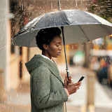 vrouw in de regen met telefoon