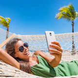 Vrouw met smartphone in hangmat