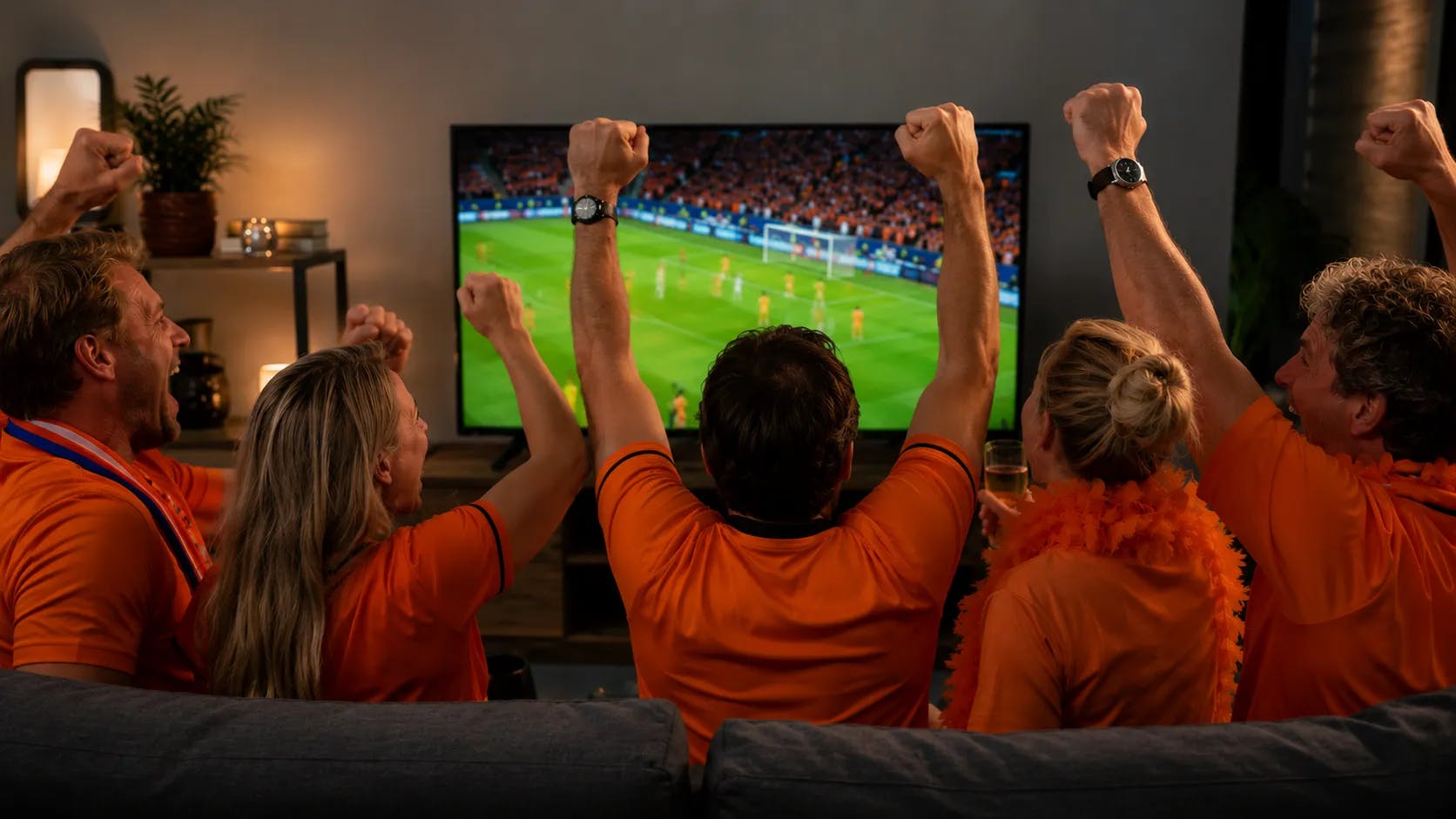 Juichende voetbalsupporters die Oranje aanmoedigen.