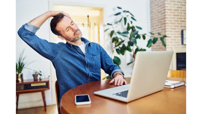 Man met achter laptop op werkplek die oefening doet tegen RSI en KANS