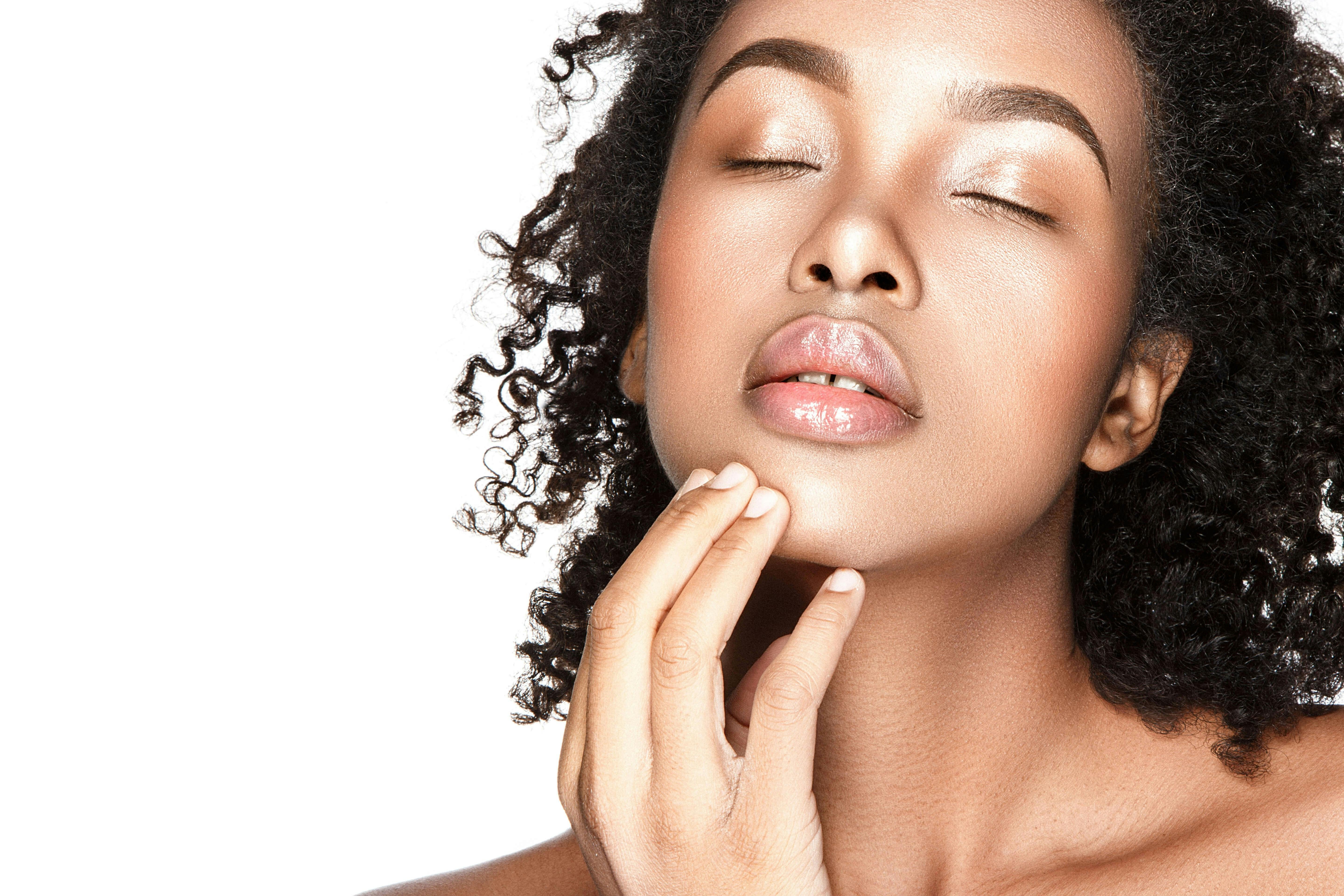 Black woman closing her eyes touching her chin