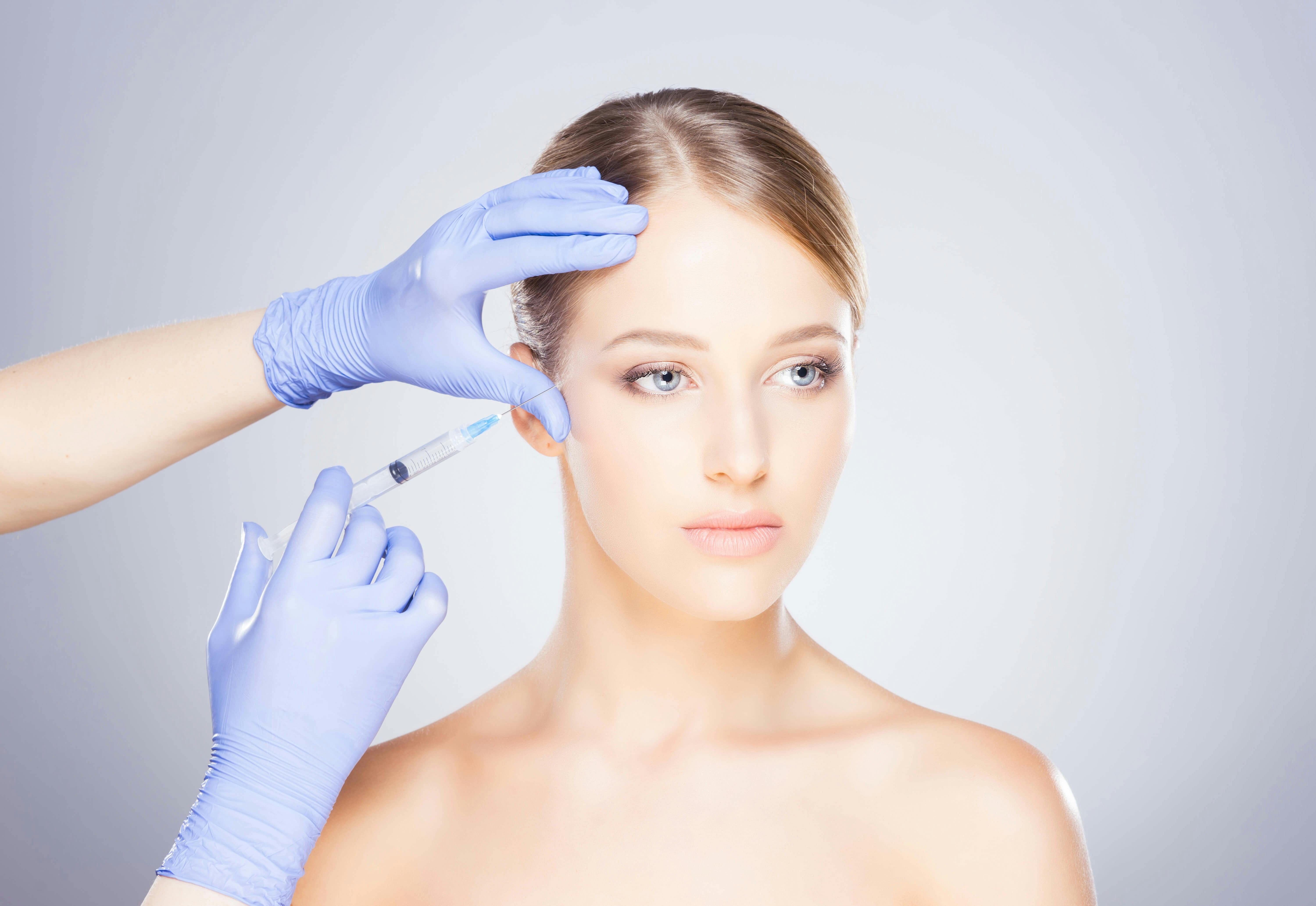A woman getting an injection in her face