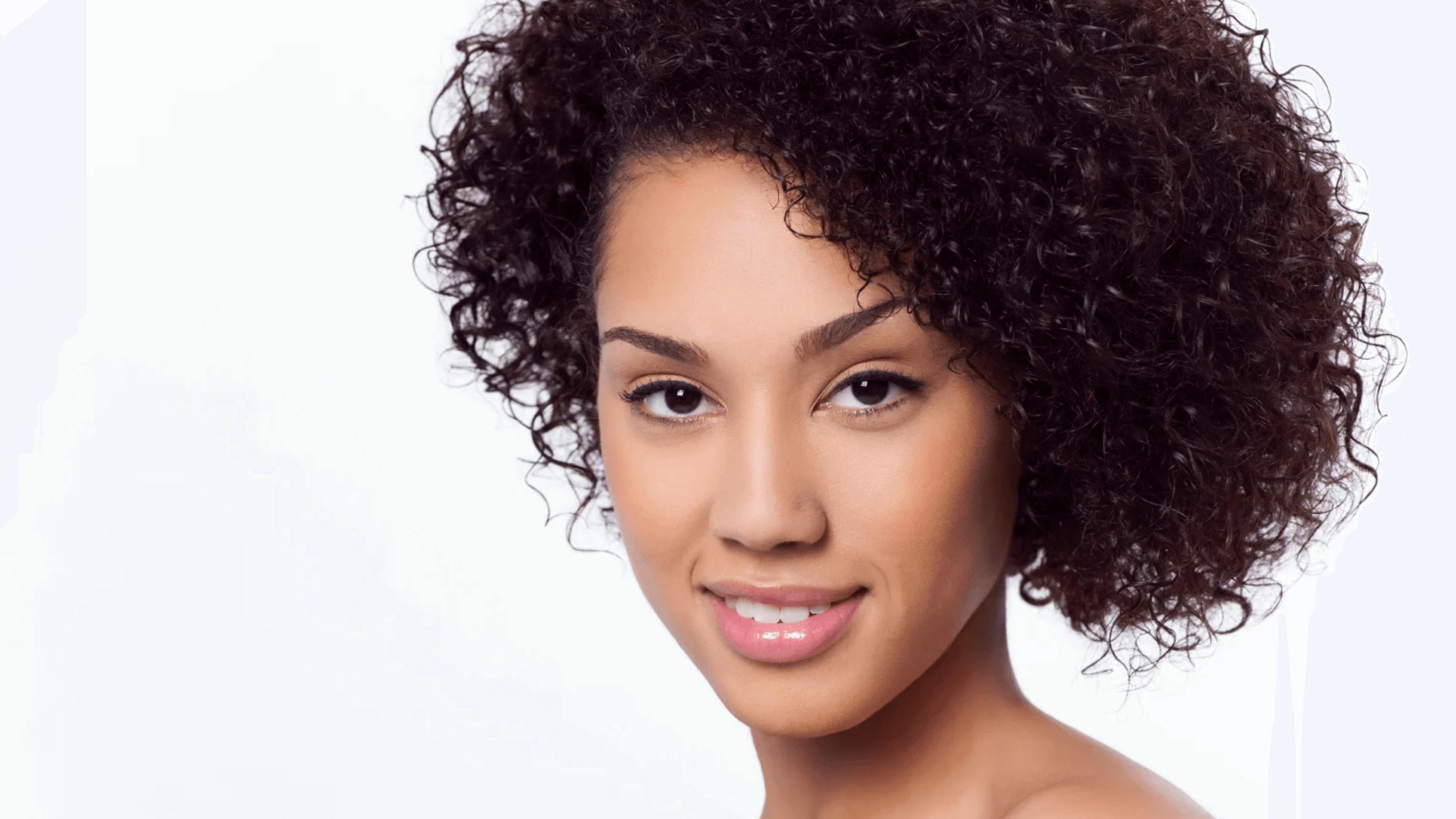 Woman wwith really curly hair looking at camera
