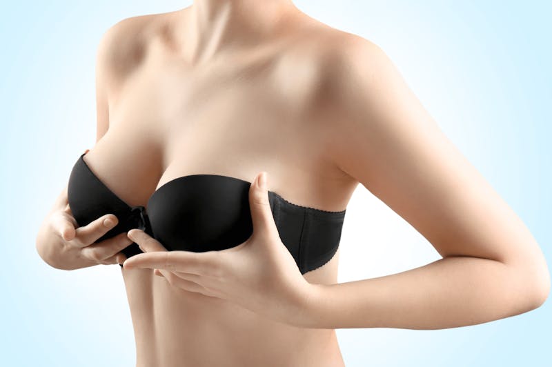 A woman touching her black bra