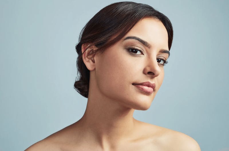 A brunette woman tilting her head to the side
