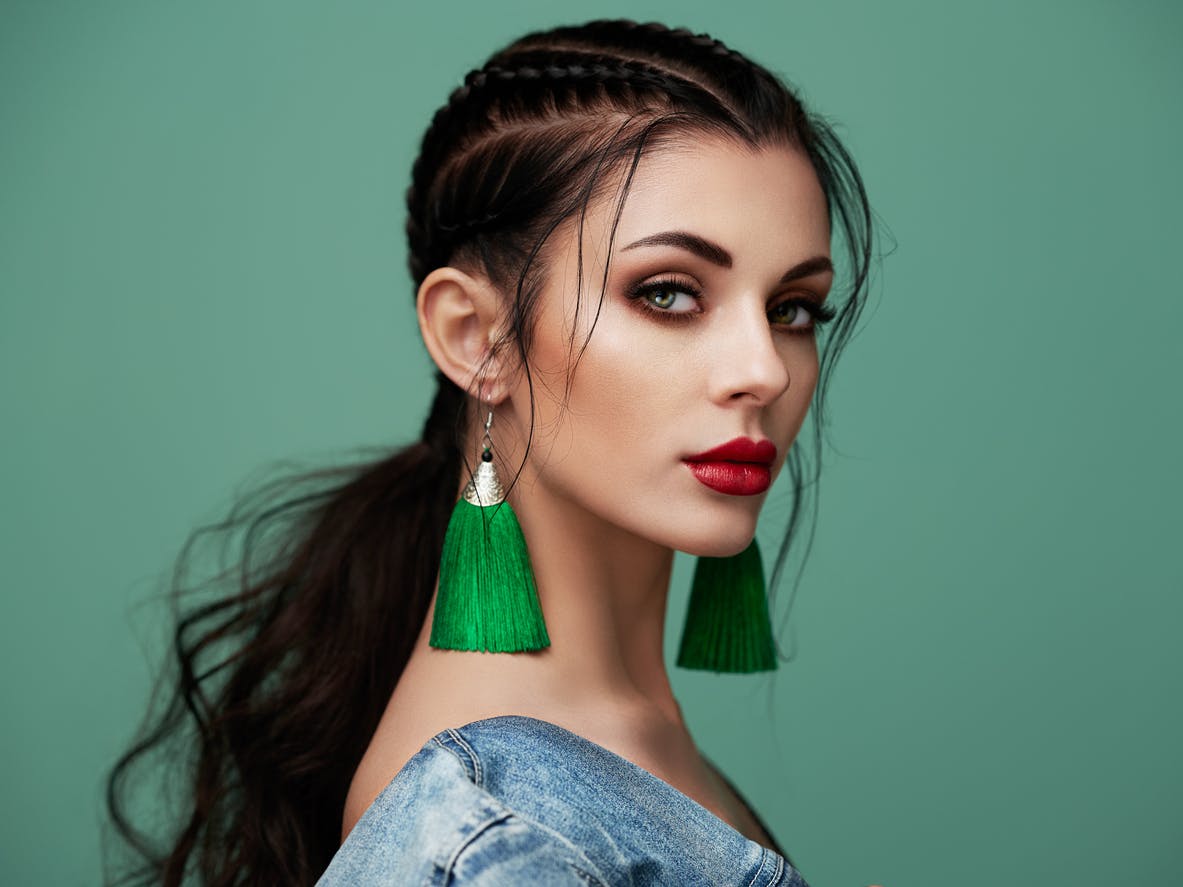 Woman in green earings and denim coat