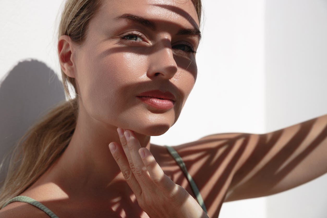 A woman's face with shadows from a tree