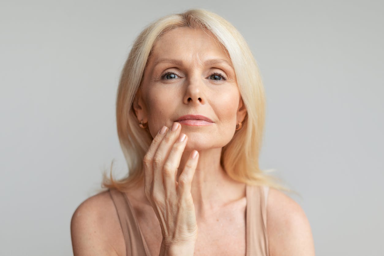 Woman looking the camera touching her face