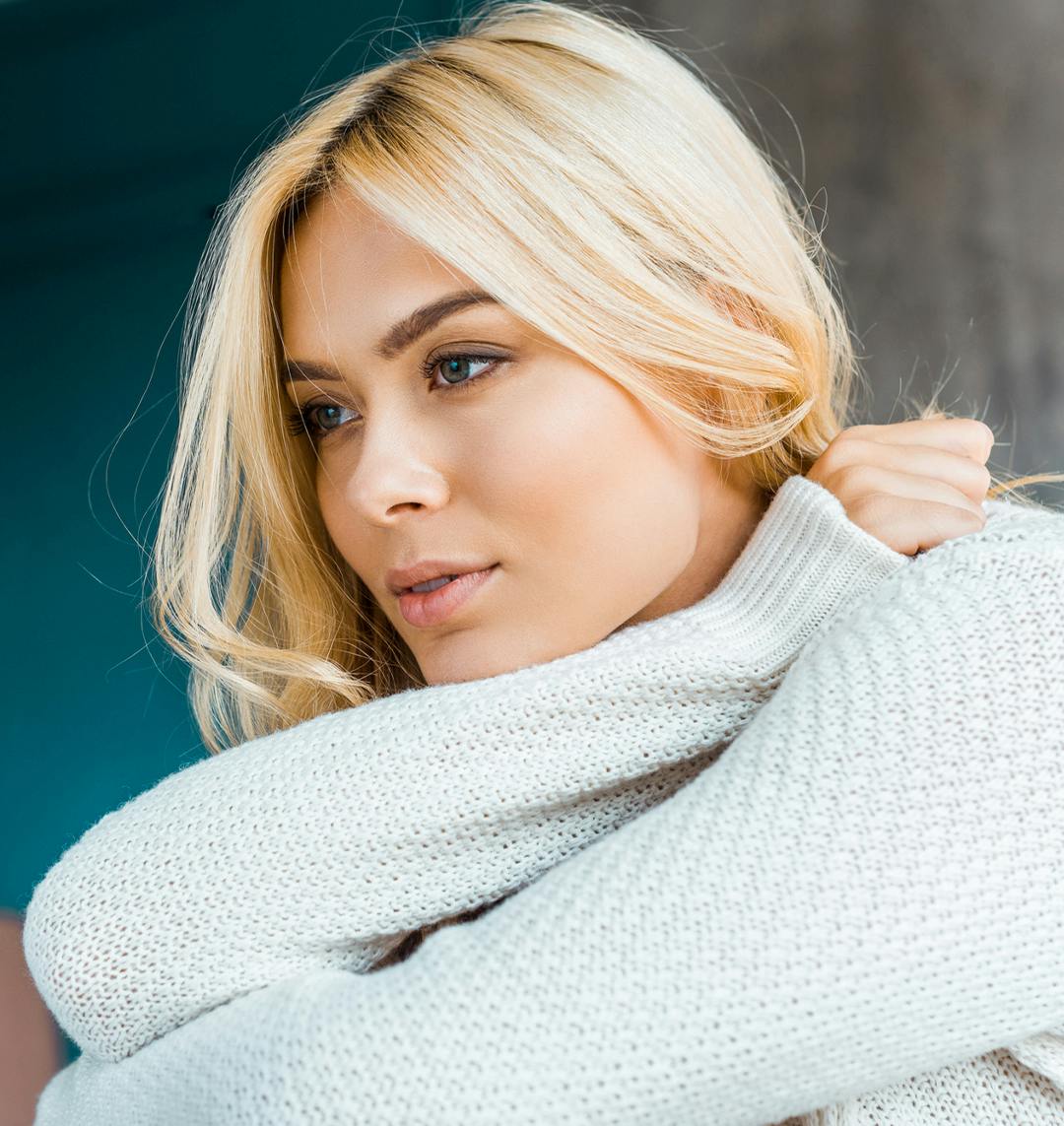 woman with blonde hair wearing a sweater