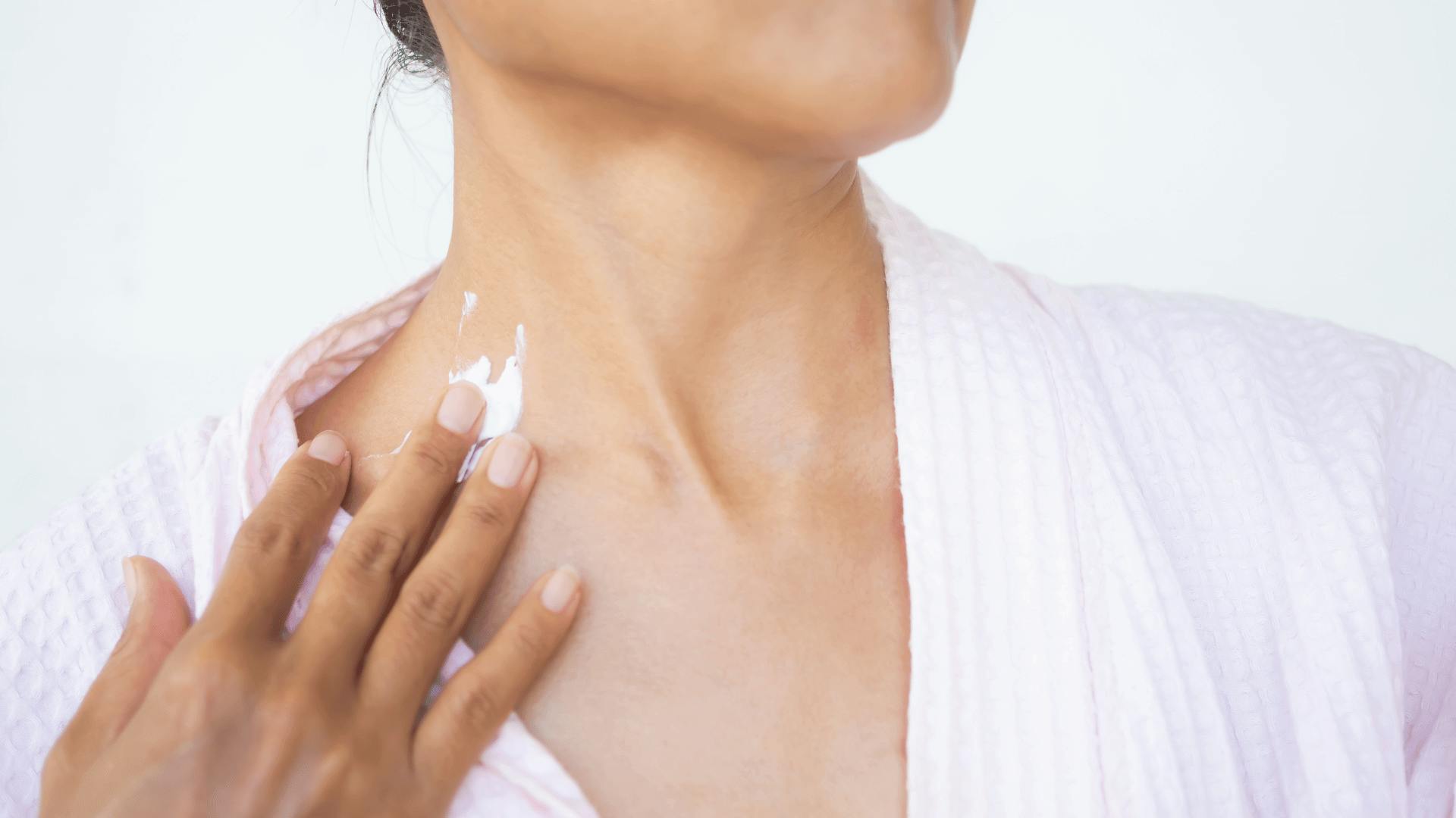 women applying cream to neck