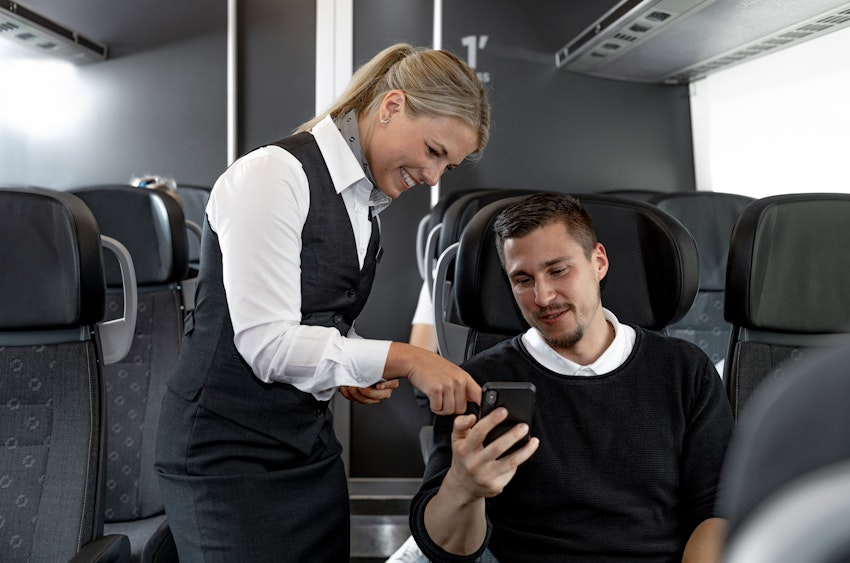 Tågvärd hjälper resenär med biljett i mobiltelefon