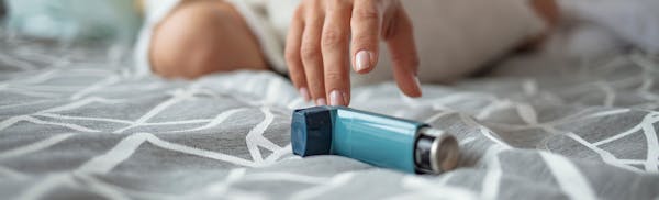 woman reaching for inhaler