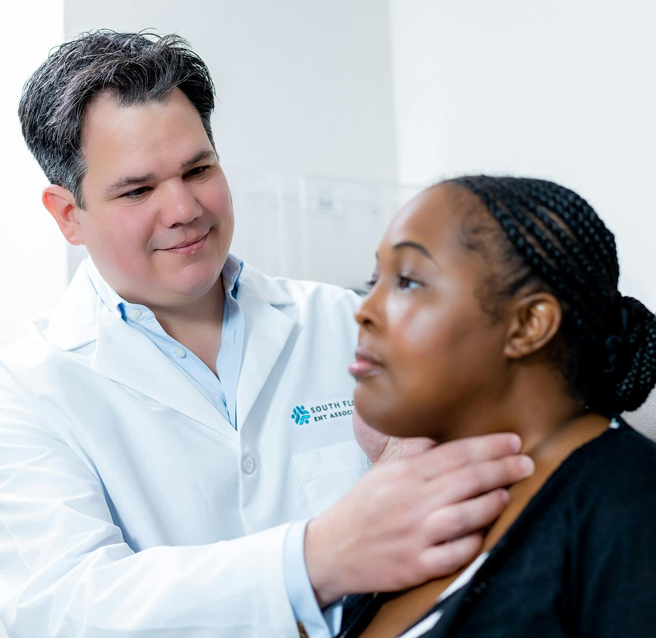 there is a male doctor examining a woman's neck with a stethoscope