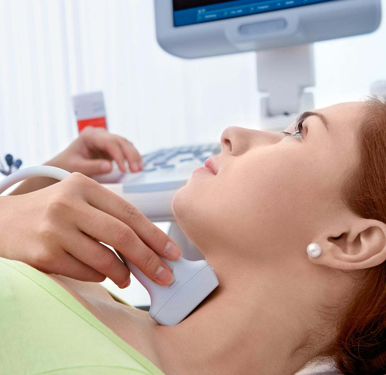 woman laying on a bed with a computer and a monitor
