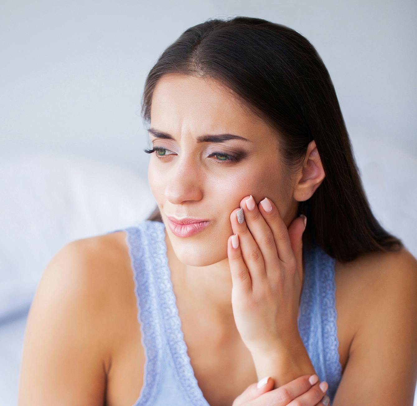 there is a woman that is holding her hand to her face