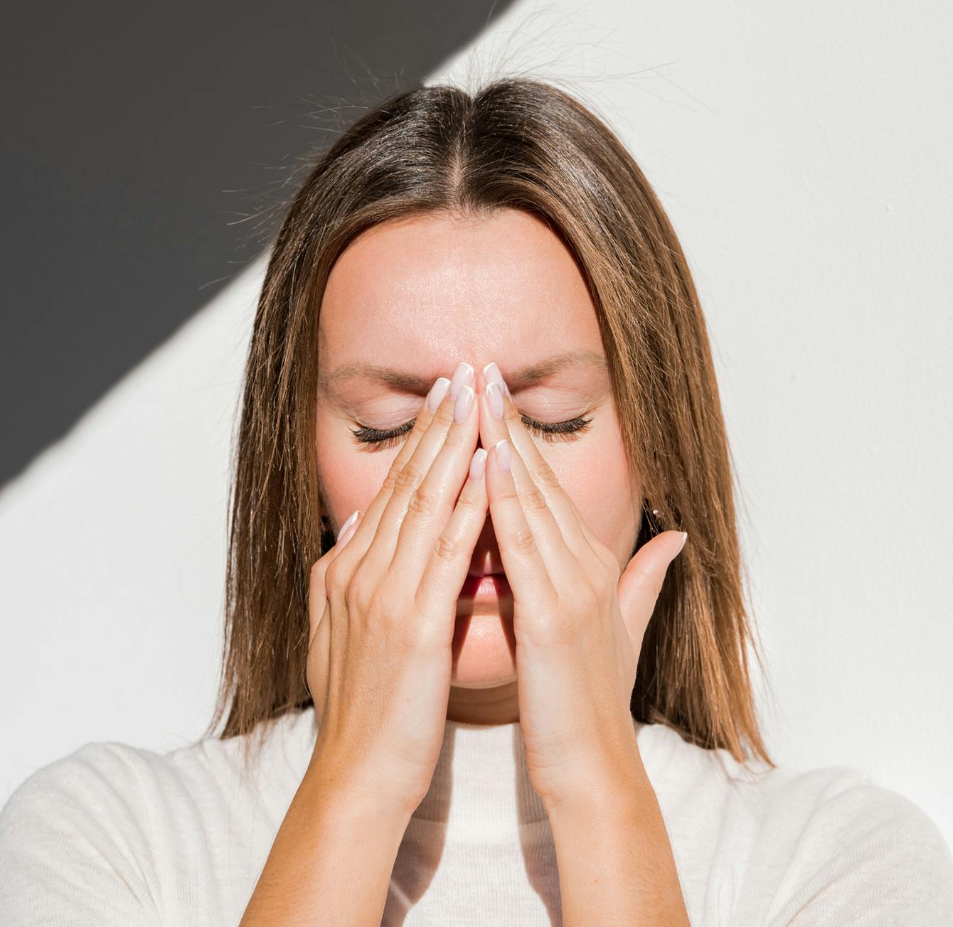there is a woman covering her face with her hands