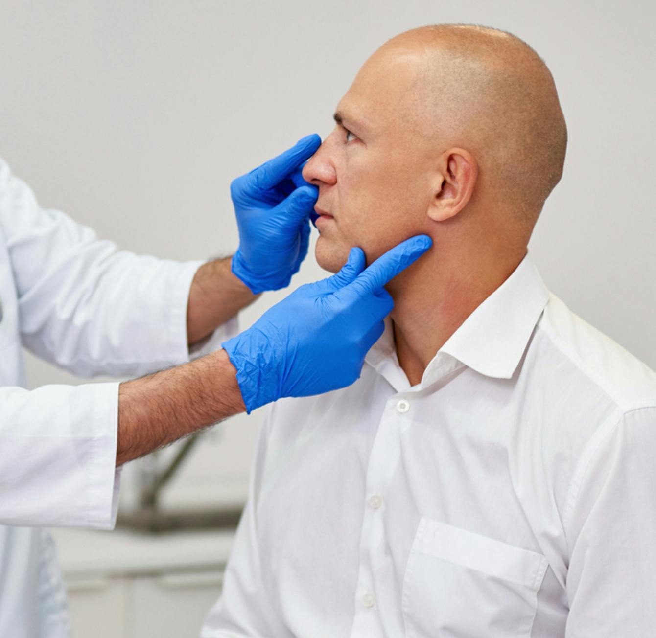 man getting neck inspected by a doctor
