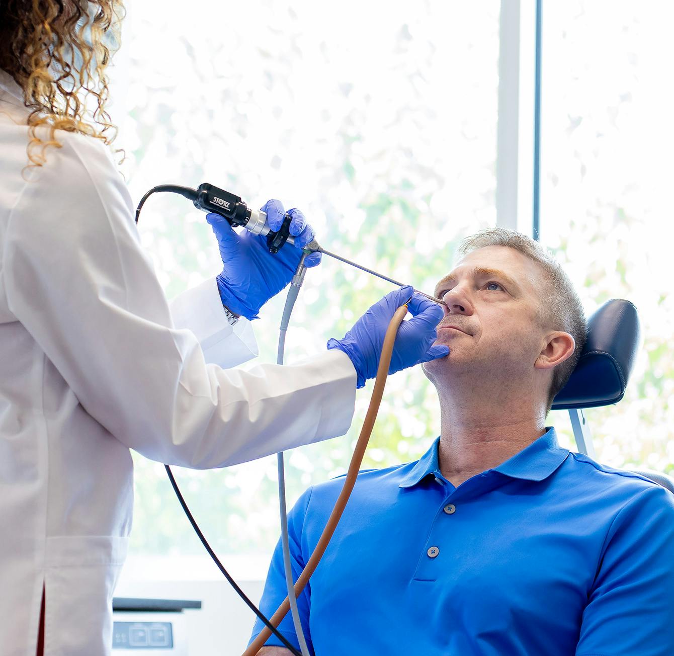 male patient in a chair being examined by a doctor