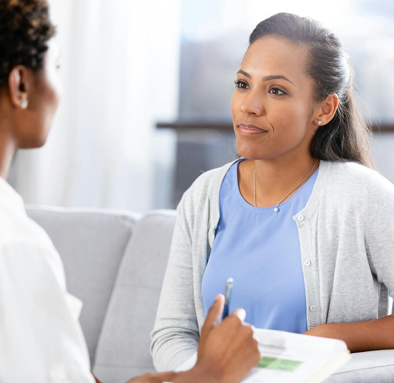 woman sitting on a couch talking to a doctor