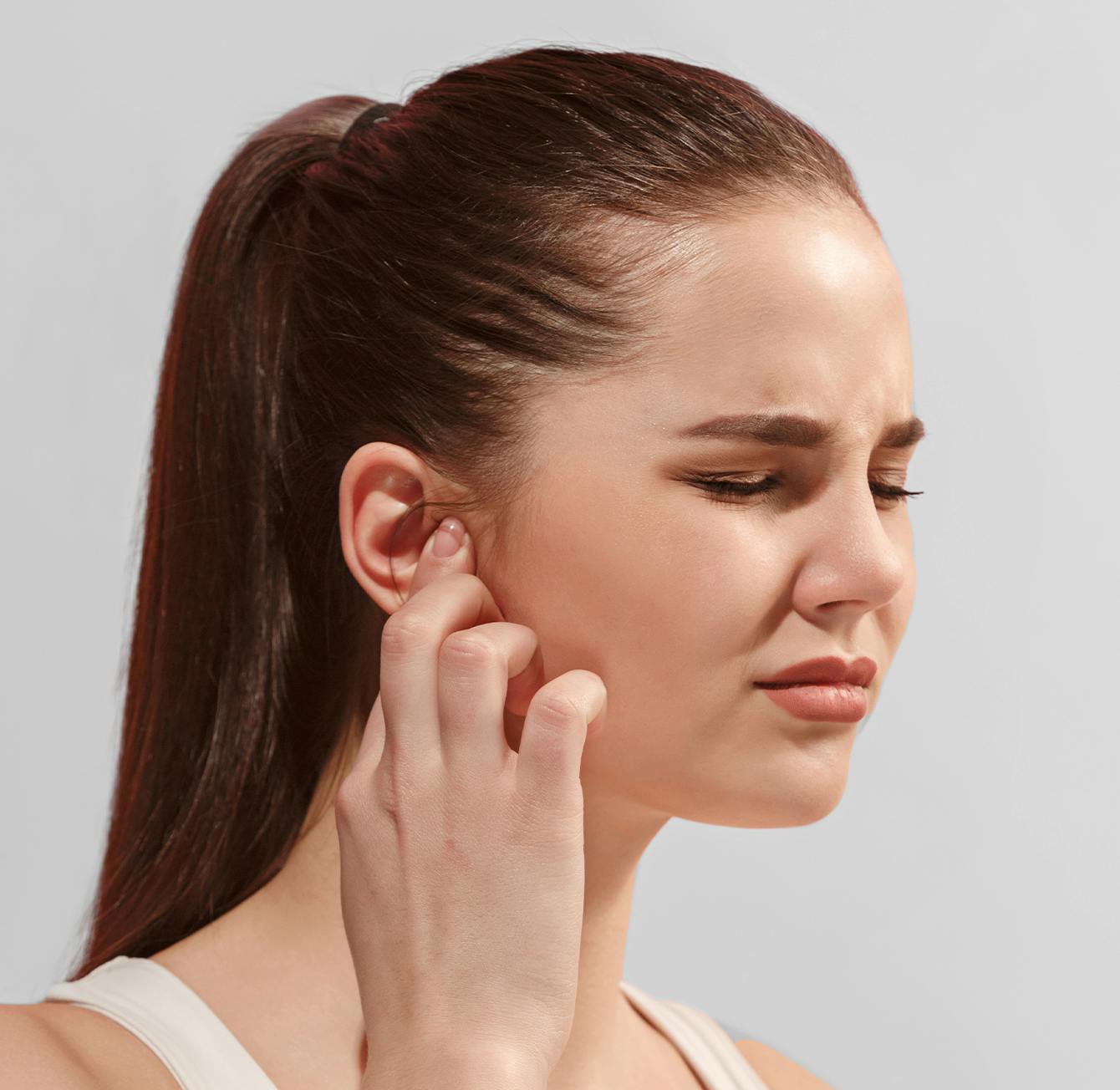 there is a woman with a ponytail holding her ear to her ear