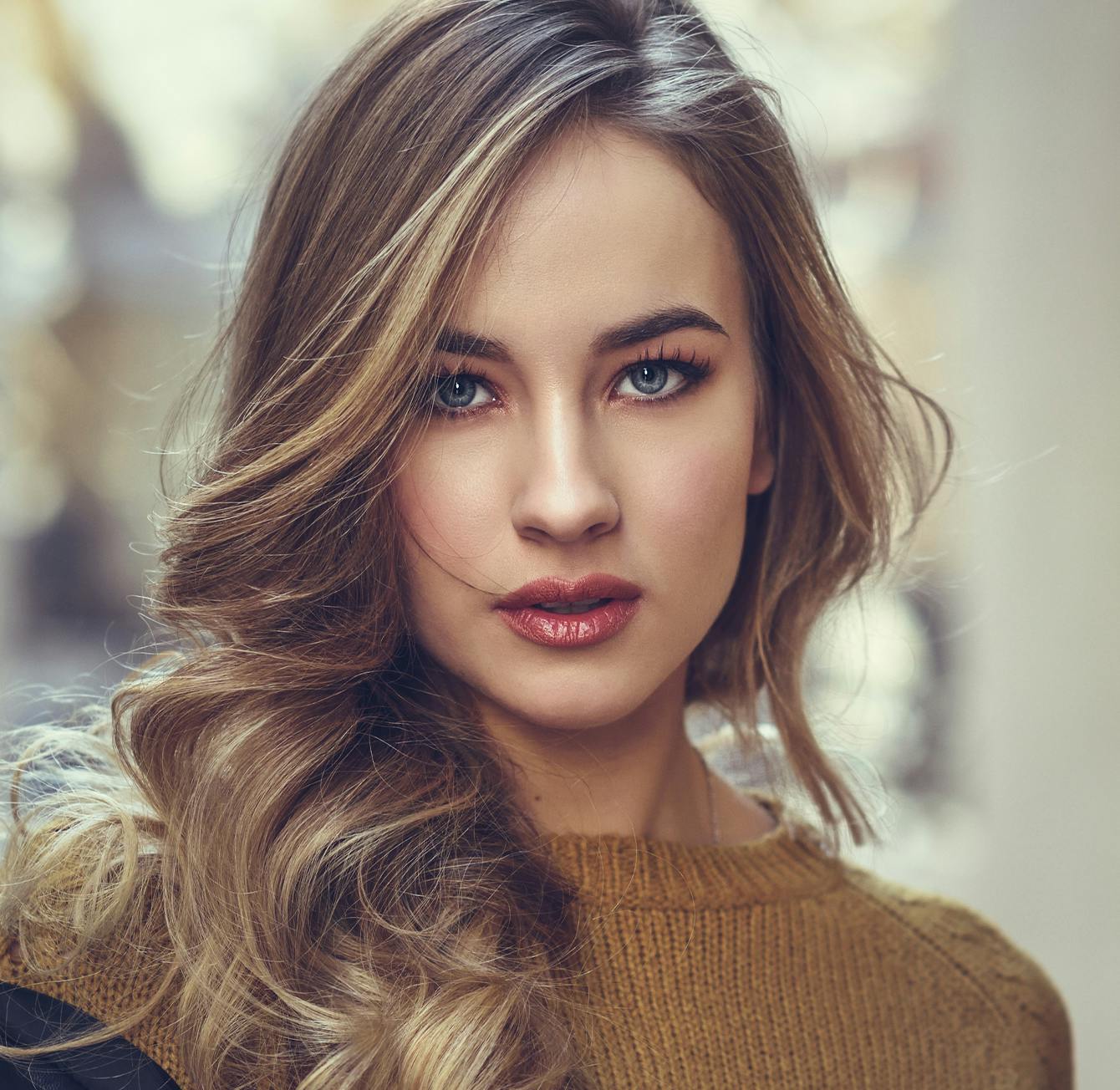 blond woman with long wavy hair and blue eyes posing for a picture