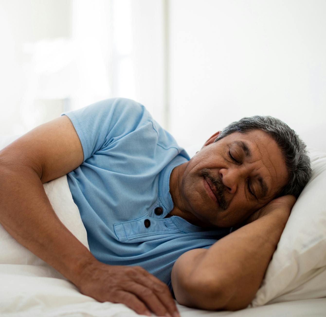 there is a man laying in bed with his eyes closed