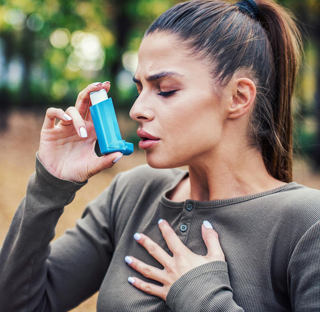 woman using an inhaler to treat her sores