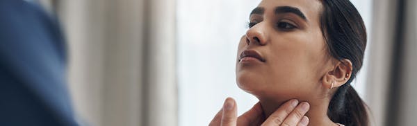 there is a woman that is touching her neck with her hands