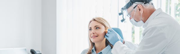 woman getting her ear examined by a doctor