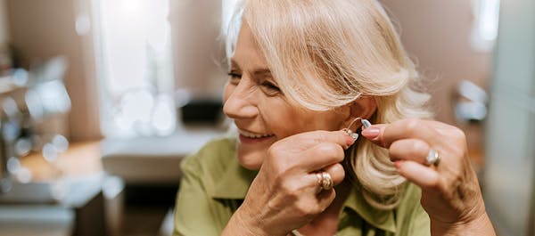 Female patient holds hearing aid