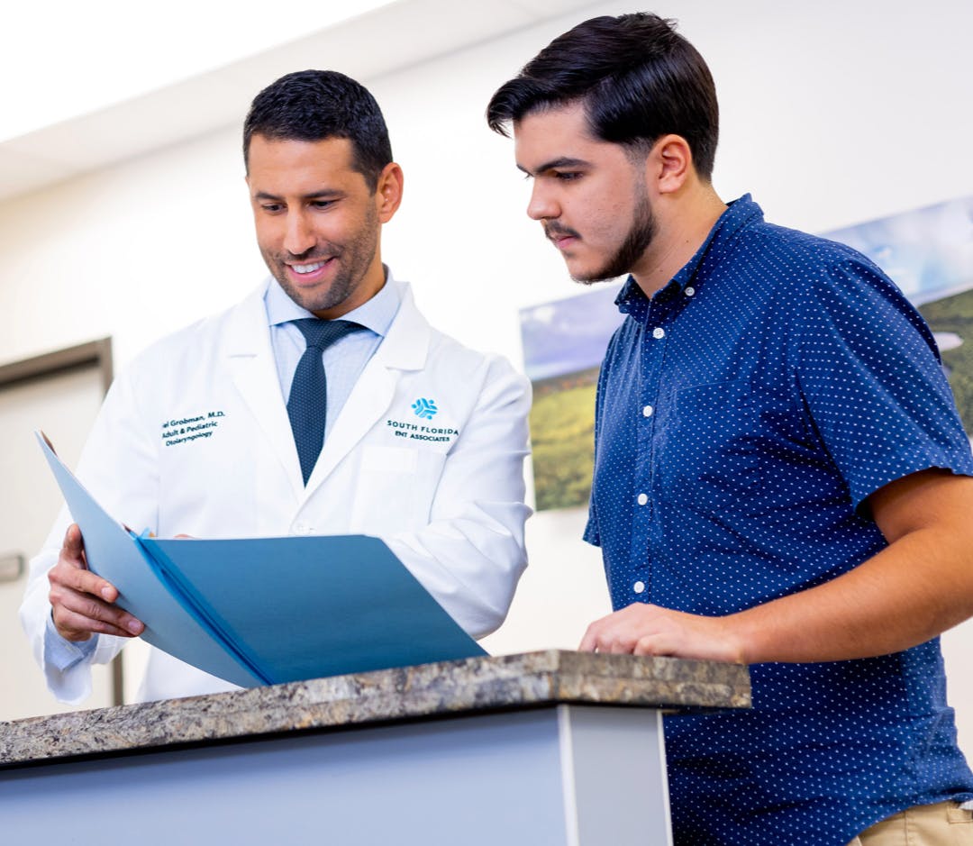 Male physician shows medical folder to male patient