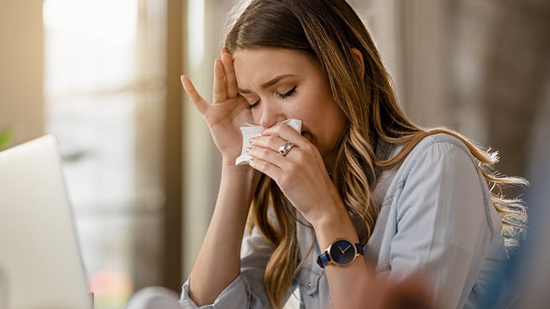 Woman blowing her nose