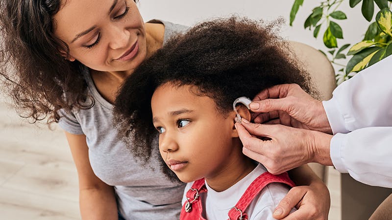 Young girl being fitted with a hearing aid