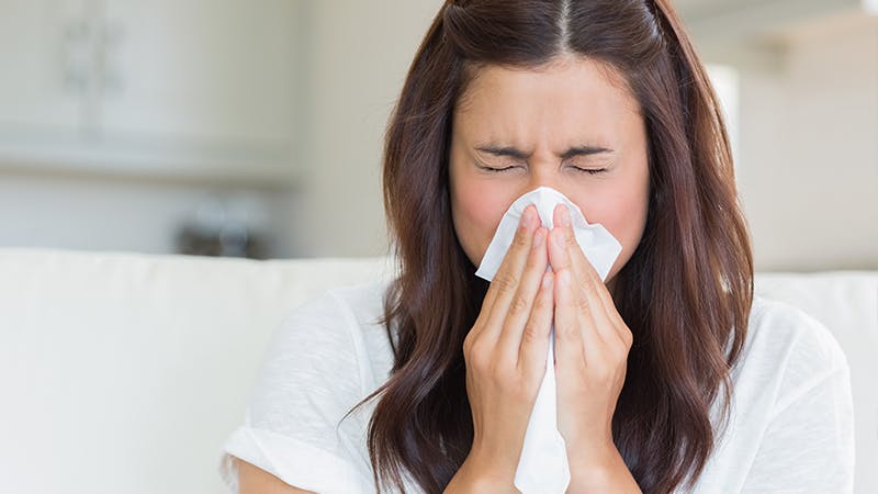 Young woman blowing her nose